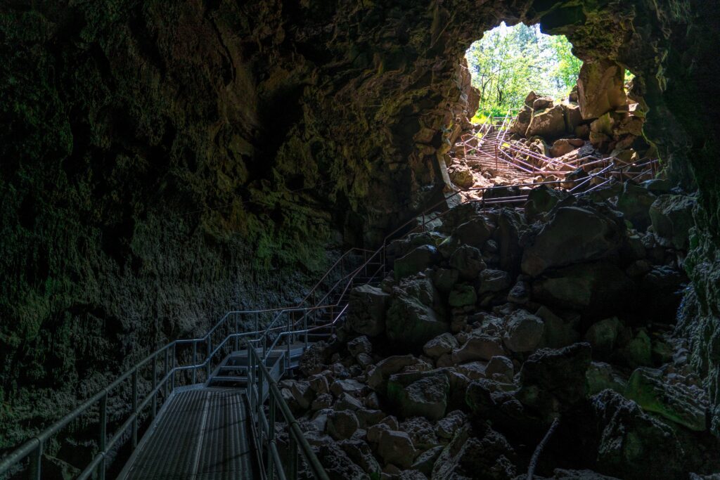 Escalier menant d’une grotte sombre vers la lumière du jour