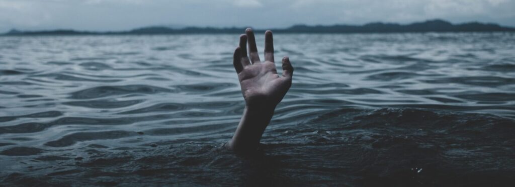 Main émergeant de l’eau sous un ciel sombre