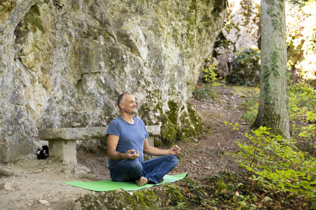Christophe assis en méditation en plein air