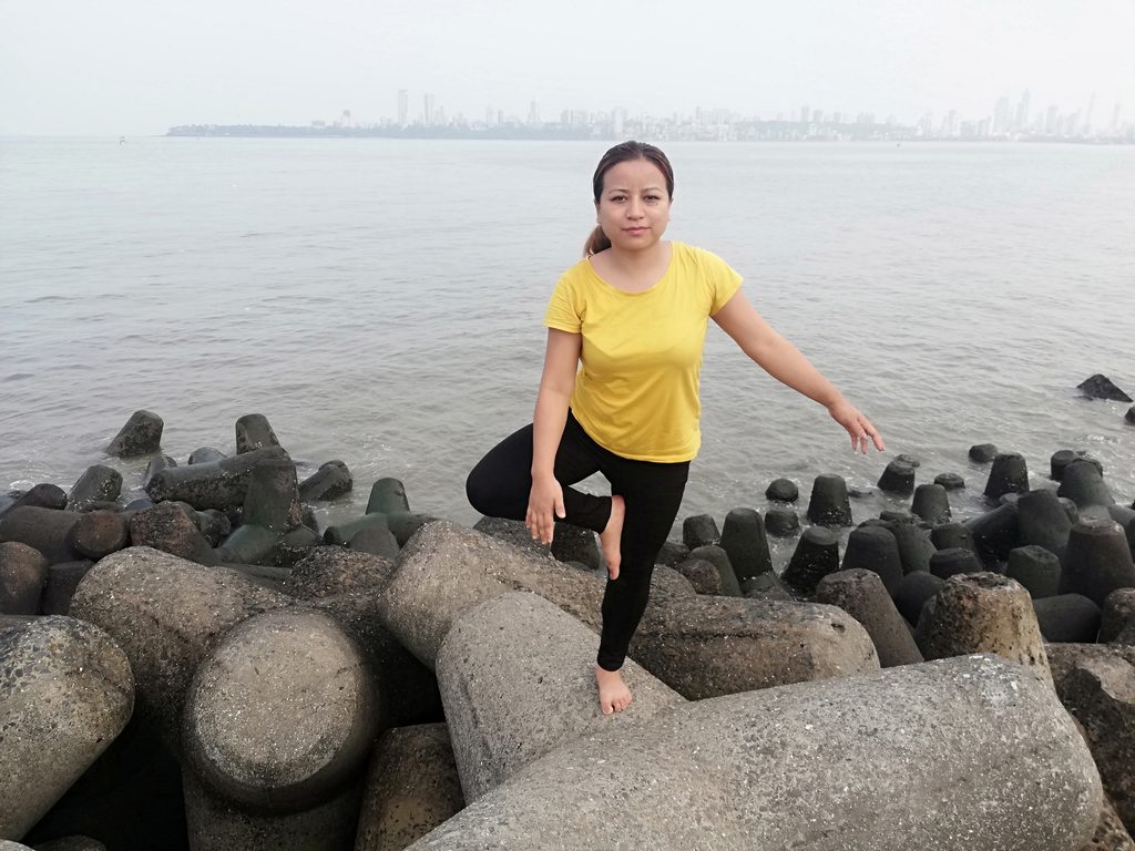 Personne pratiquant une posture de yoga au bord de l’eau
